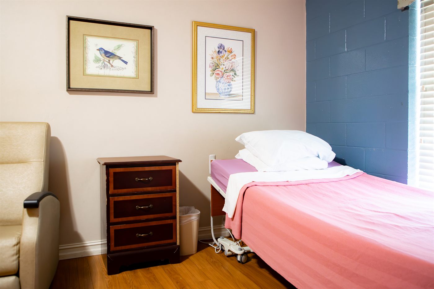 A bright respite guest suite with a freshly made bed and a comfortable chair